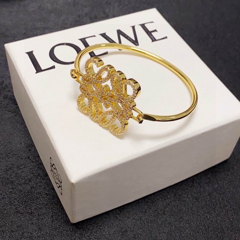 Loewe Anagram gold-tone bangle bracelet with iconic interlocking L motif, presented on Loewe gift box